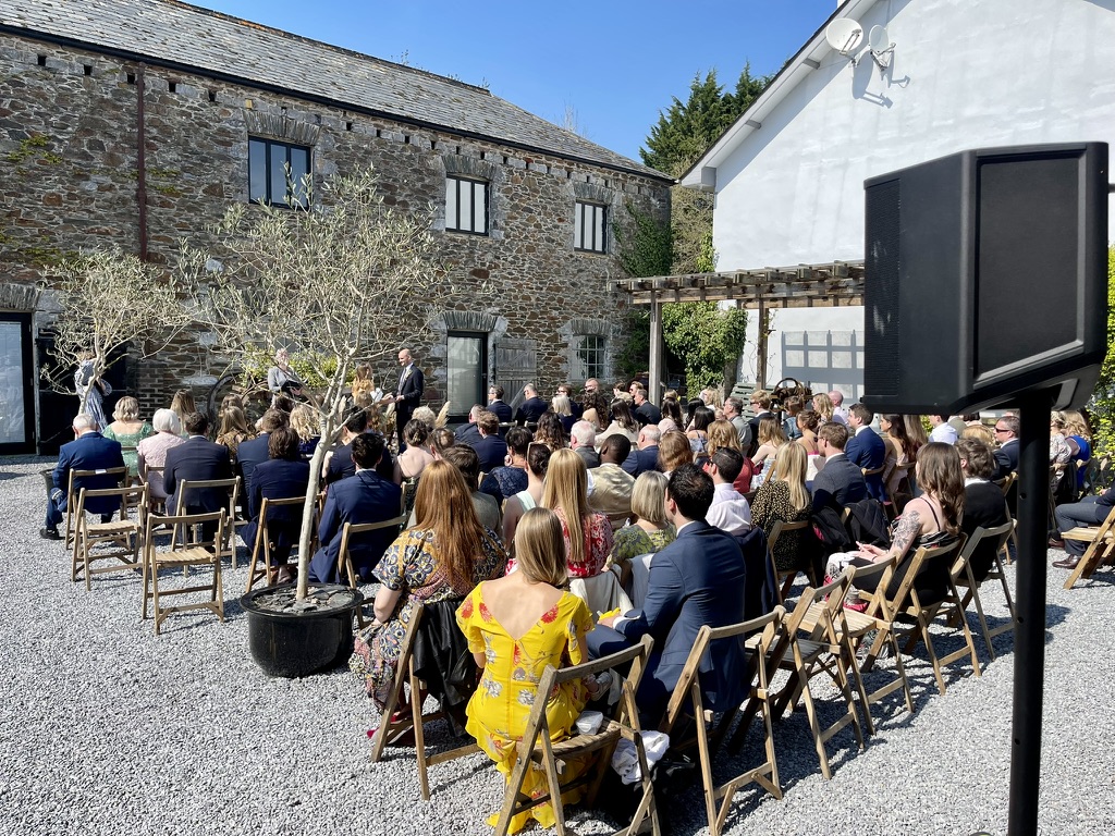 Wedding guests gathered for an outdoor courtyard ceremony