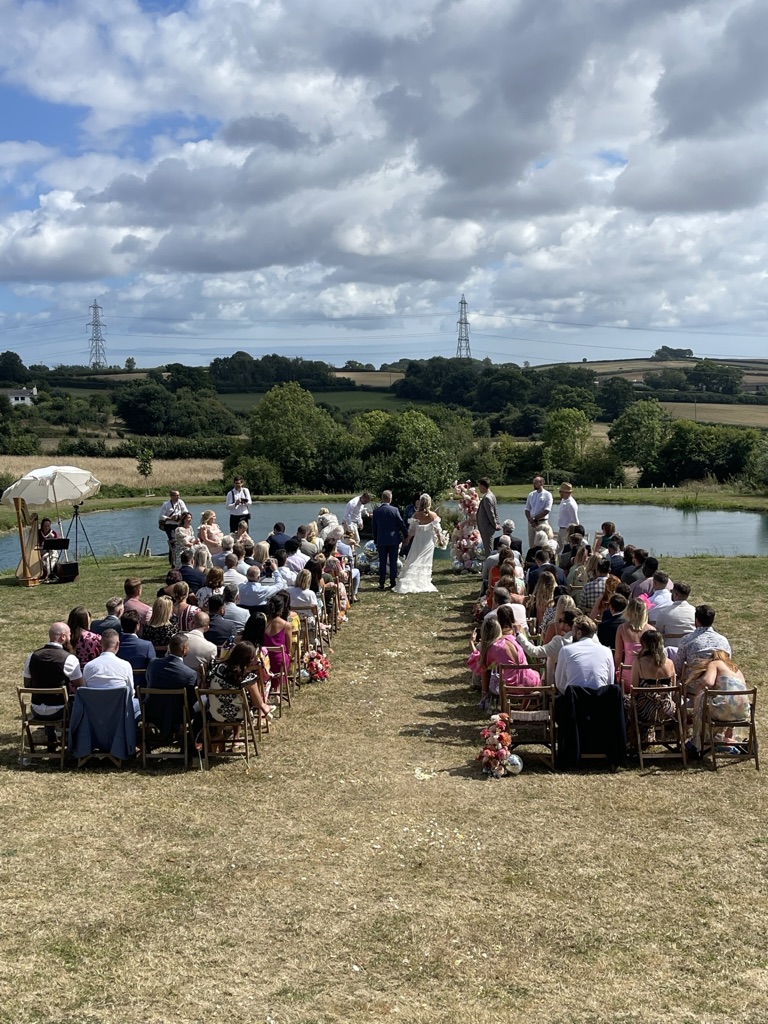 A wedding ceremony taking place beside the lake at ANRÁN